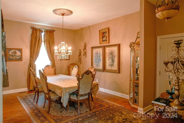 dining room featuring wood-type flooring and a notable chandelier