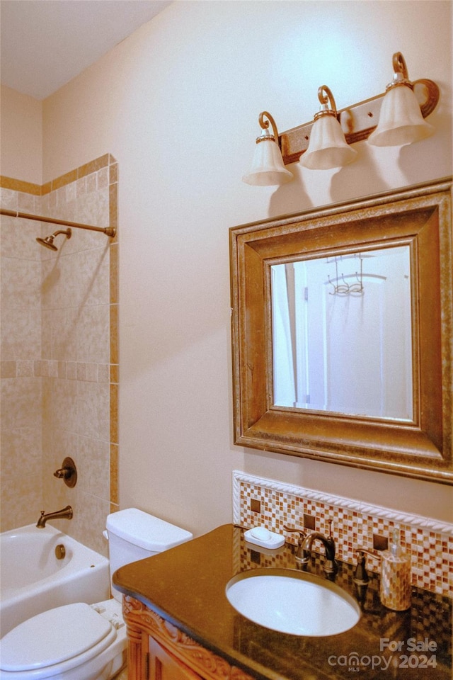 full bathroom featuring backsplash, toilet, vanity, and tiled shower / bath