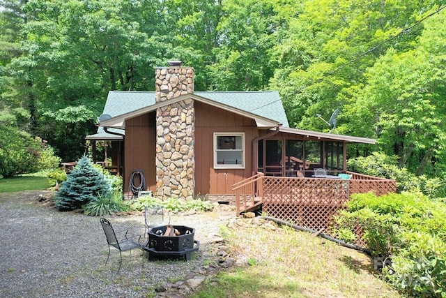 view of home's exterior featuring an outdoor fire pit and a wooden deck