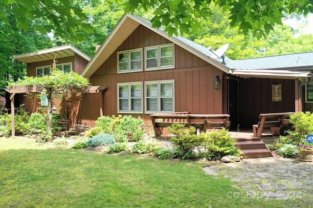 rear view of house with a deck and a lawn