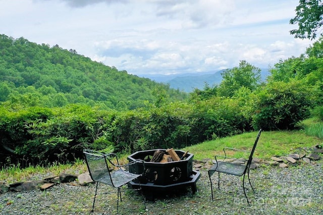 view of yard with an outdoor fire pit and a mountain view