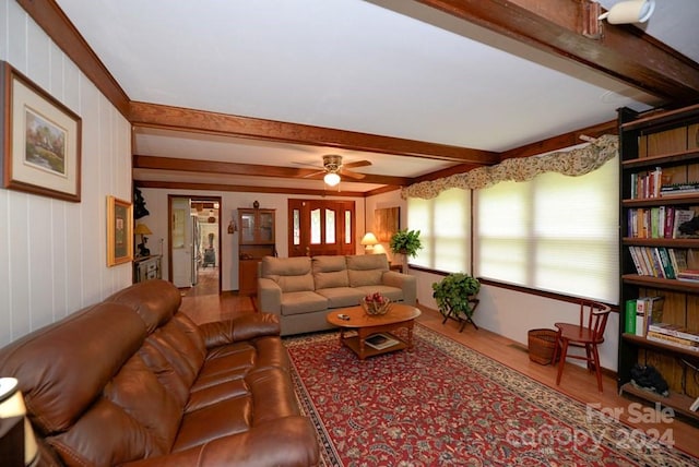 living room featuring hardwood / wood-style flooring, beam ceiling, and ceiling fan