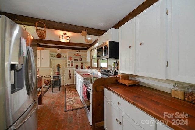 kitchen with sink, white cabinetry, appliances with stainless steel finishes, and beam ceiling