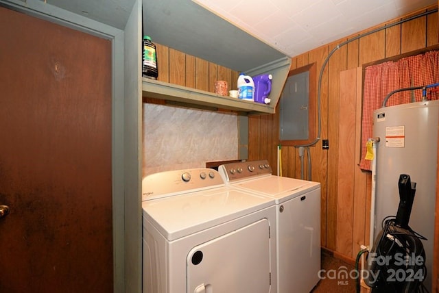 clothes washing area with wood walls, electric panel, gas water heater, and washing machine and dryer