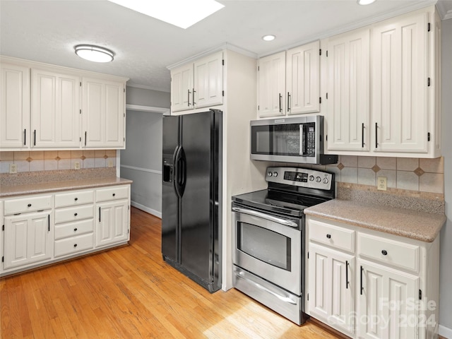 kitchen with crown molding, white cabinets, tasteful backsplash, light wood-type flooring, and stainless steel appliances