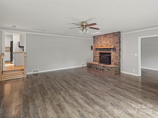 unfurnished living room featuring a fireplace, a textured ceiling, dark hardwood / wood-style floors, and ceiling fan