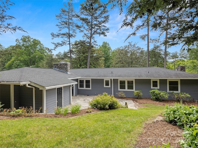 back of property with a lawn and a patio