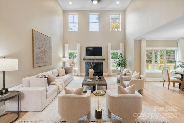 4023 Randolph Rd, Charlotte, NC 28211 - living area with a high ceiling, plenty of natural light, light wood-style floors, baseboards, and a glass covered fireplace