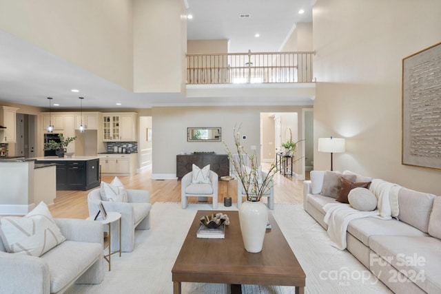 living room with a high ceiling and light hardwood / wood-style flooring