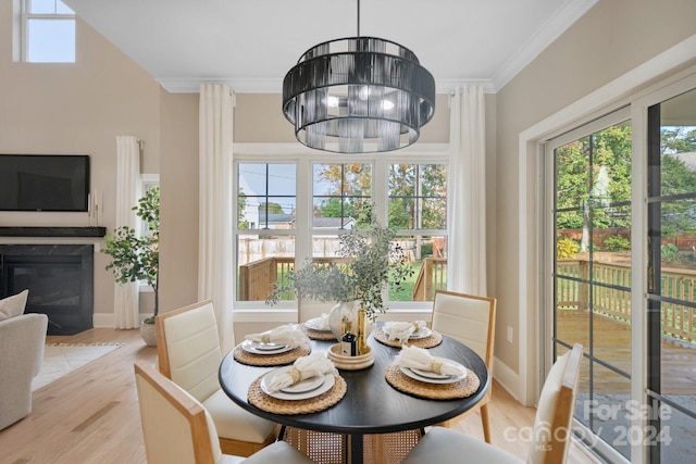 dining area with a chandelier, light hardwood / wood-style flooring, and crown molding