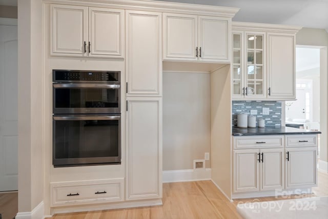 4023 Randolph Rd, Charlotte, NC 28211 - kitchen featuring double oven, light wood-type flooring, baseboards, glass insert cabinets, and tasteful backsplash
