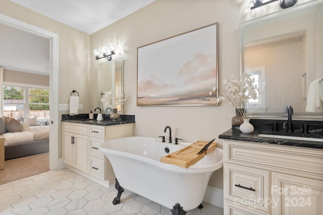 bathroom with a tub to relax in, tile patterned floors, and vanity