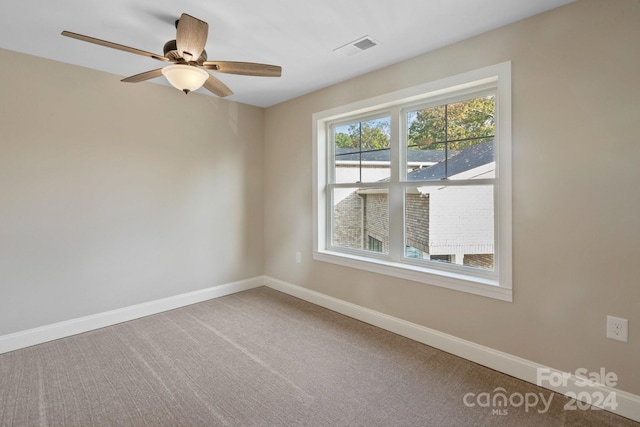 carpeted spare room with ceiling fan