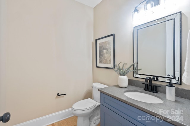 bathroom featuring hardwood / wood-style flooring, vanity, and toilet