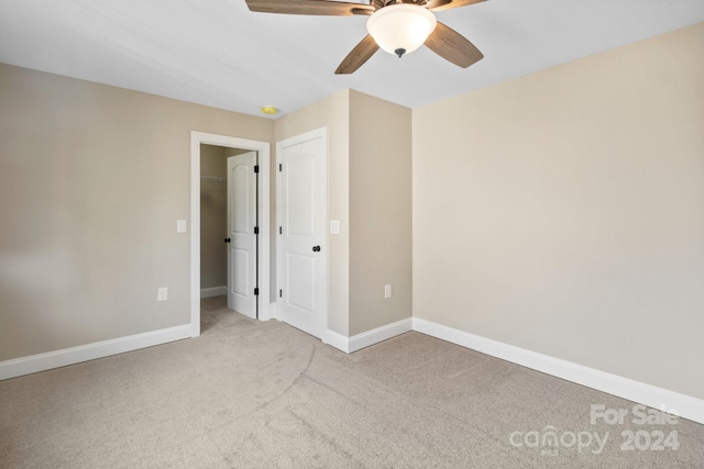 empty room with ceiling fan and light colored carpet