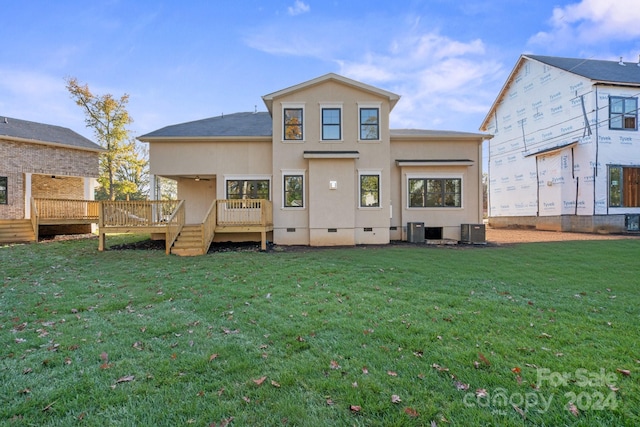 rear view of house with a lawn, a wooden deck, and cooling unit