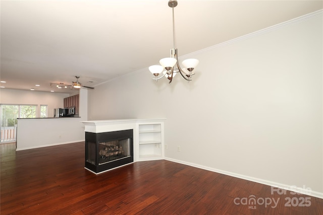 unfurnished living room featuring crown molding, baseboards, dark wood-style flooring, and a multi sided fireplace