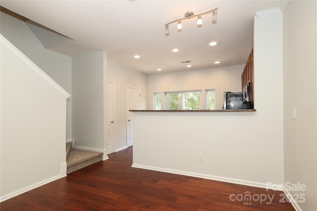 empty room with dark wood-type flooring, recessed lighting, and baseboards