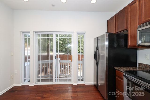 kitchen with stainless steel appliances, recessed lighting, dark wood-type flooring, dark stone counters, and baseboards