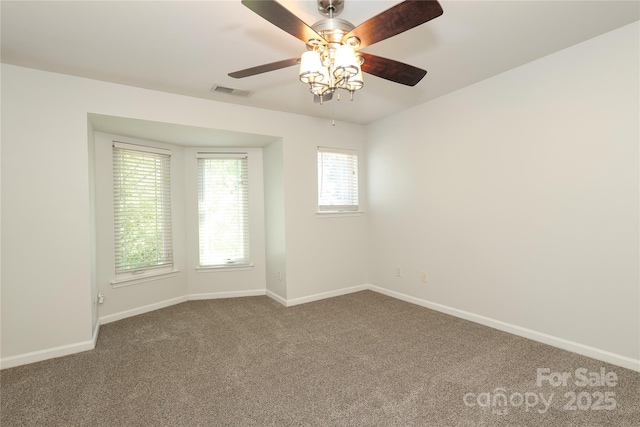 spare room with a ceiling fan, carpet flooring, visible vents, and baseboards