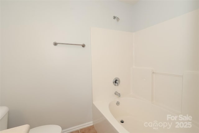 bathroom featuring a bath, tile patterned flooring, toilet, and baseboards