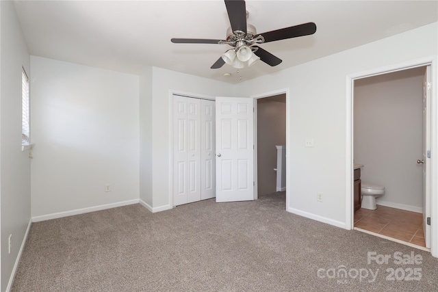 unfurnished bedroom with ensuite bath, a closet, carpet flooring, and baseboards