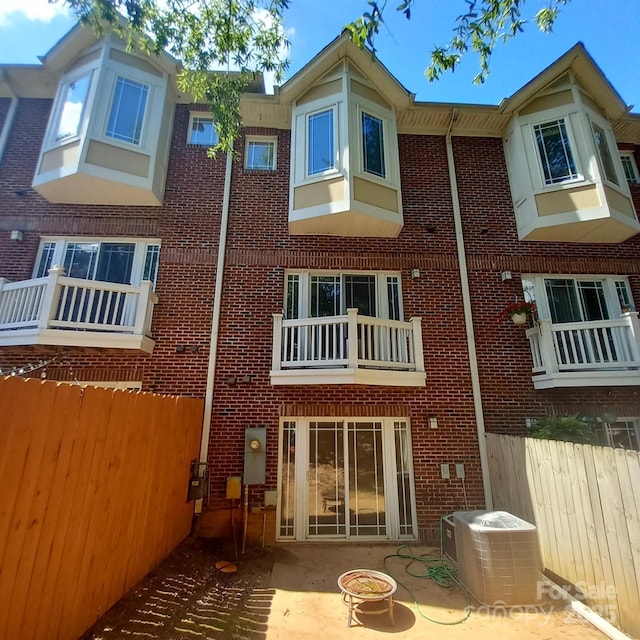 back of house featuring a patio, fence, central AC, and brick siding