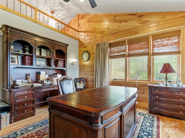 home office featuring ceiling fan, lofted ceiling, light hardwood / wood-style floors, and wooden walls