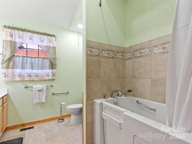 bathroom featuring toilet, vanity, a bathtub, and tile patterned floors