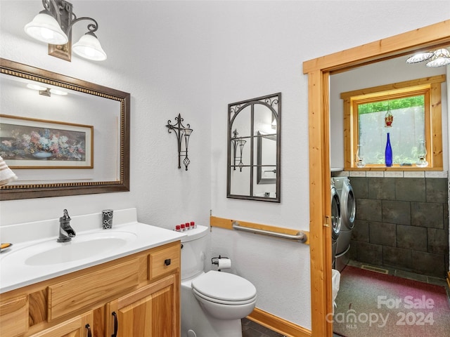 bathroom with toilet, washer and dryer, and vanity