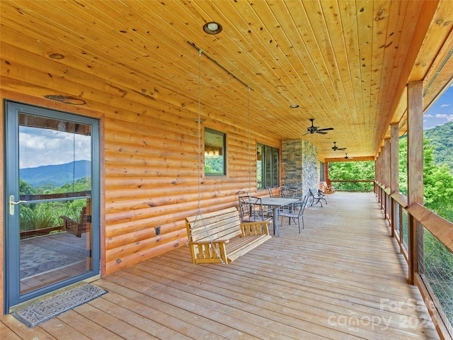 wooden deck featuring a mountain view and ceiling fan