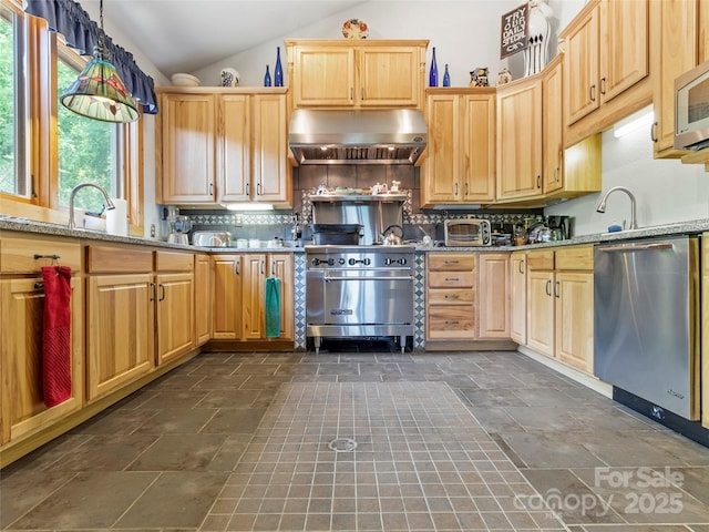 kitchen featuring stainless steel appliances, lofted ceiling, backsplash, stone finish floor, and extractor fan