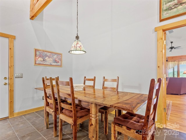 dining space with ceiling fan and baseboards