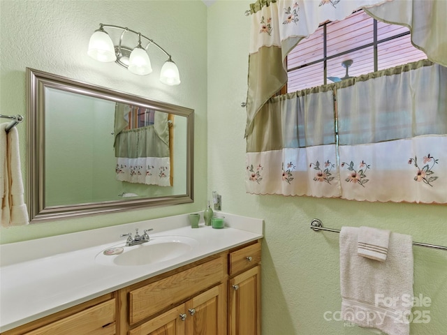 bathroom featuring a textured wall and vanity