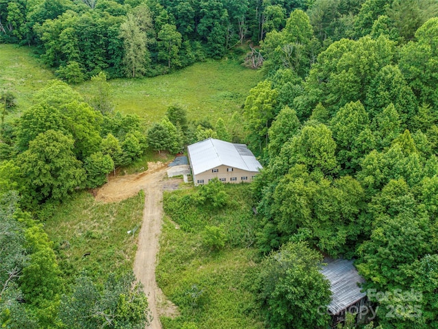 birds eye view of property featuring a forest view