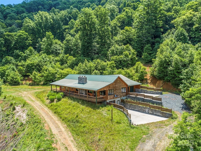 birds eye view of property featuring a forest view