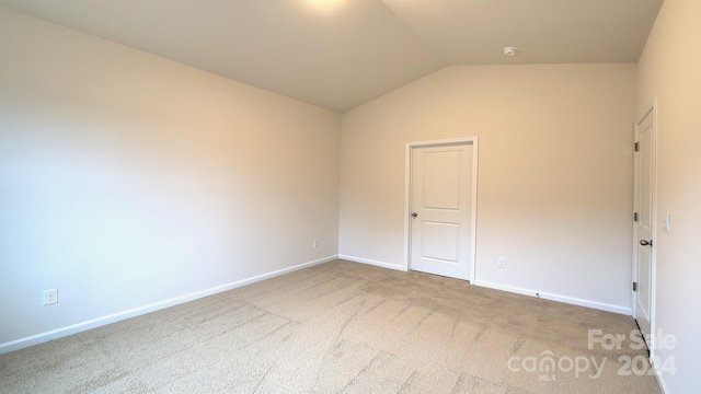 empty room with carpet and lofted ceiling