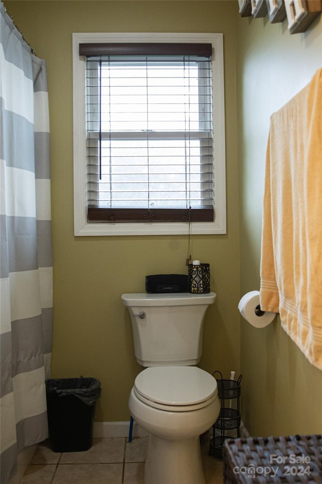 bathroom with plenty of natural light, toilet, and tile patterned flooring