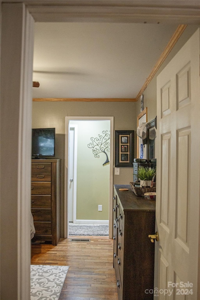 hall featuring light wood-type flooring and ornamental molding