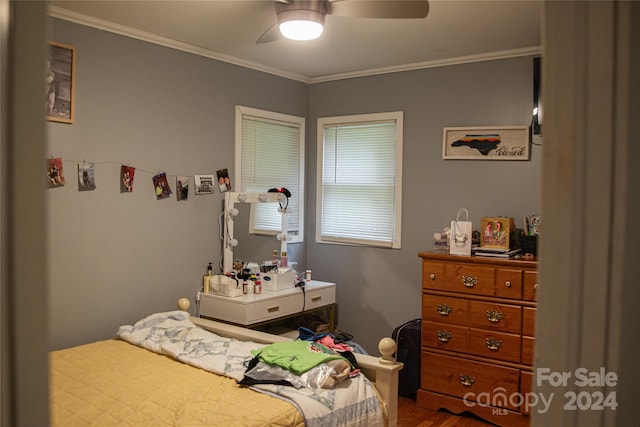 bedroom with ceiling fan, crown molding, and wood-type flooring