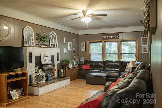 living room with a textured ceiling, light wood-type flooring, and wooden walls