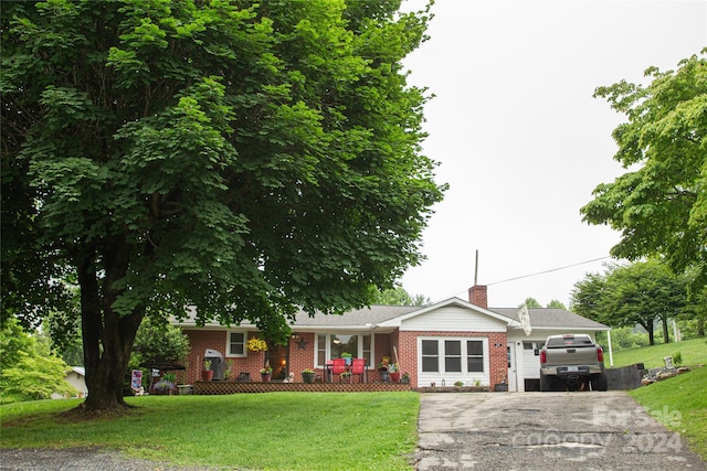 ranch-style home with a front lawn, a porch, and a garage