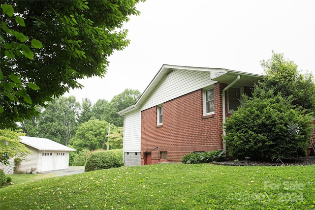 view of side of home with a garage, a yard, and an outdoor structure