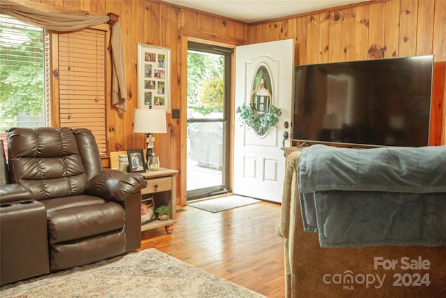 living room featuring wooden walls and light hardwood / wood-style flooring