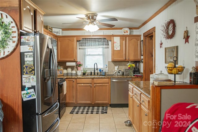 kitchen with sink, crown molding, stainless steel appliances, light tile patterned floors, and dark stone counters