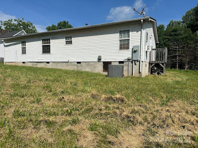 back of property featuring central AC and a yard