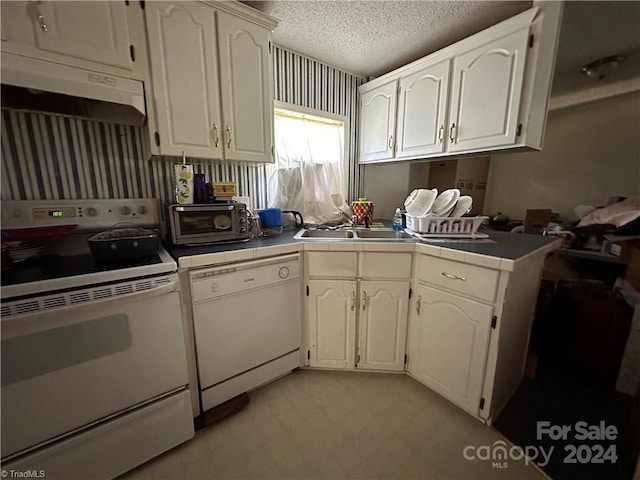 kitchen featuring white cabinetry, sink, kitchen peninsula, a textured ceiling, and white appliances