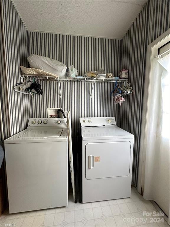 laundry room featuring a textured ceiling and washing machine and clothes dryer