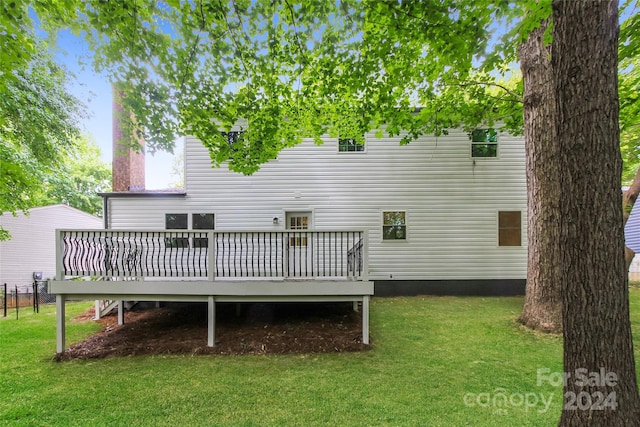 rear view of house featuring a yard and a wooden deck