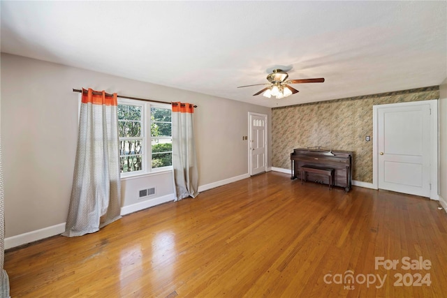 unfurnished living room featuring hardwood / wood-style floors and ceiling fan